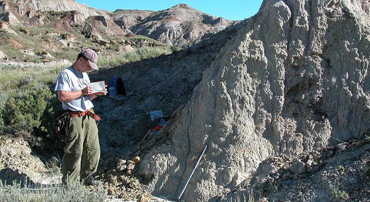 Francois Therrien writes in a notebook in the badlands.